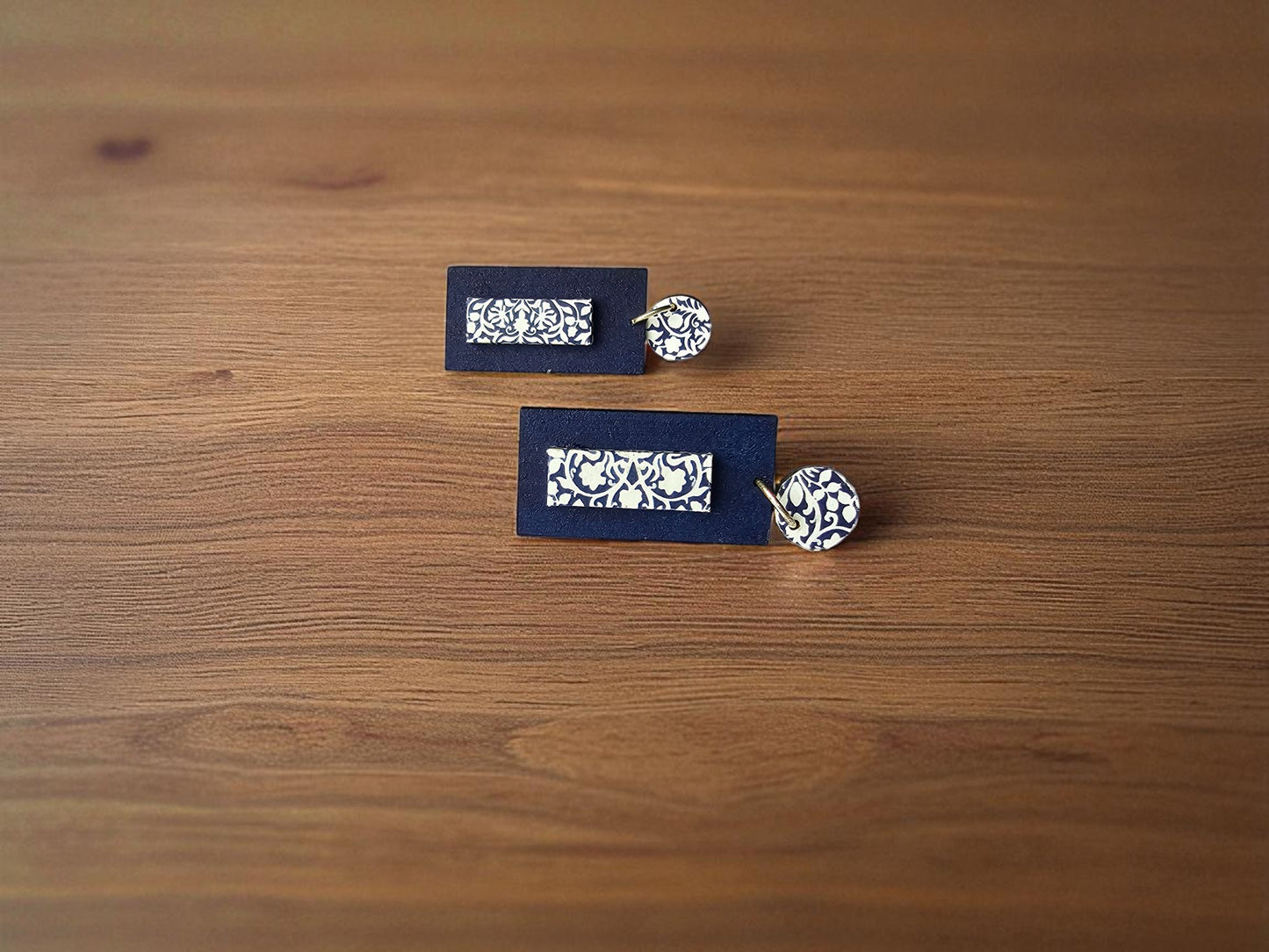 Pair of cufflinks with decorative boxes on a wooden surface