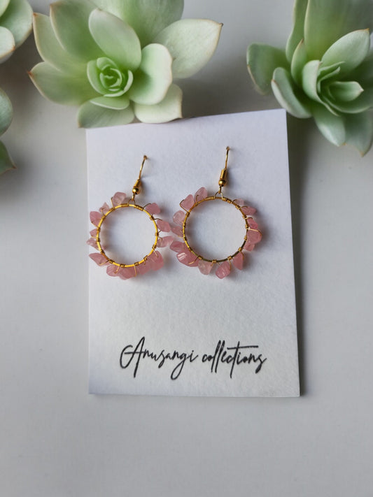 Agatha pink beaded hoop earrings from Anusangi Collections displayed on branded card with green succulents