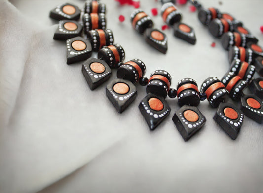 Anusangi Collections black terracotta jewelry set with geometric shapes and intricate hand-painted designs