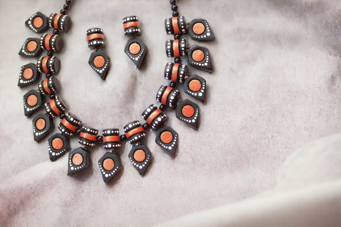 Anusangi Collections black terracotta jewelry set with necklace and matching earrings on soft fabric