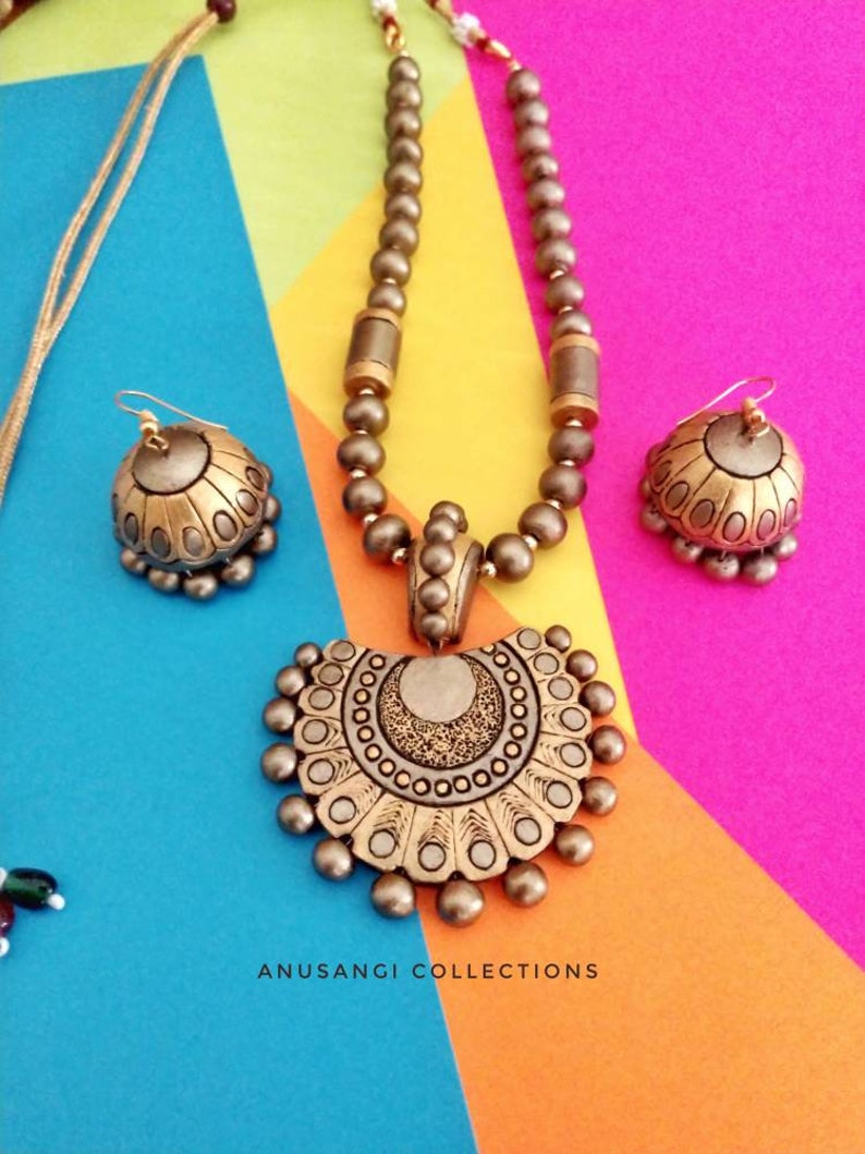 Anusangi Collections handmade terracotta jewelry set with necklace and matching earrings on colorful background