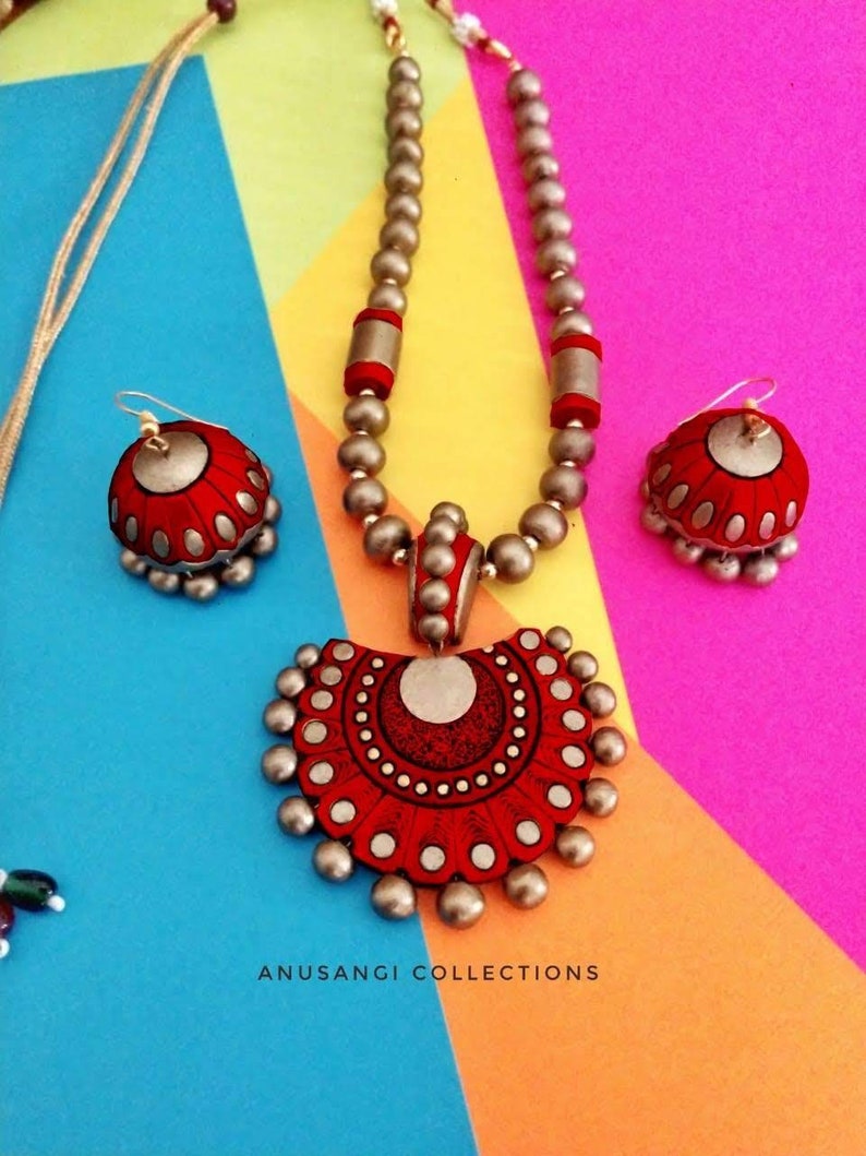 Handmade terracotta jewelry set from Anusangi Collections featuring red and beige necklace and matching earrings