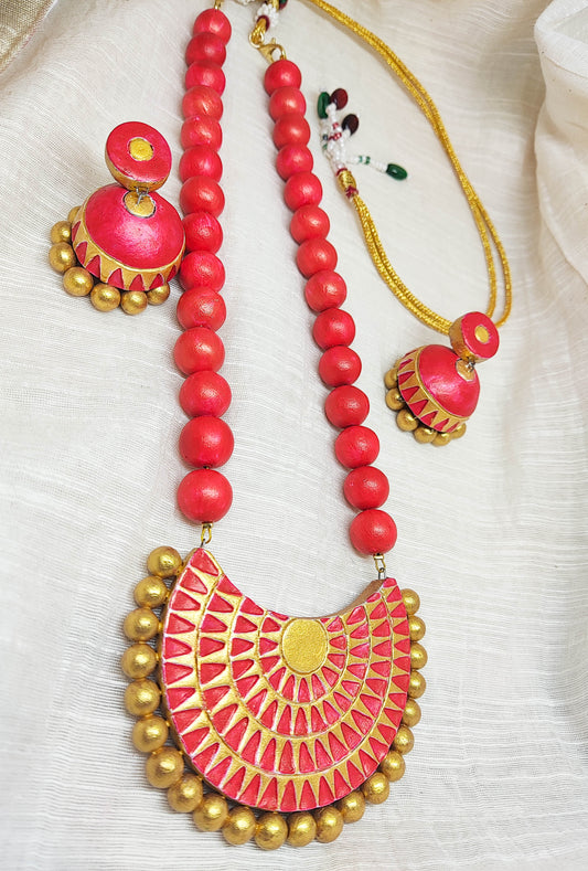 Anya terracotta jewelry set by Anusangi Collections featuring red and gold necklace and matching earrings