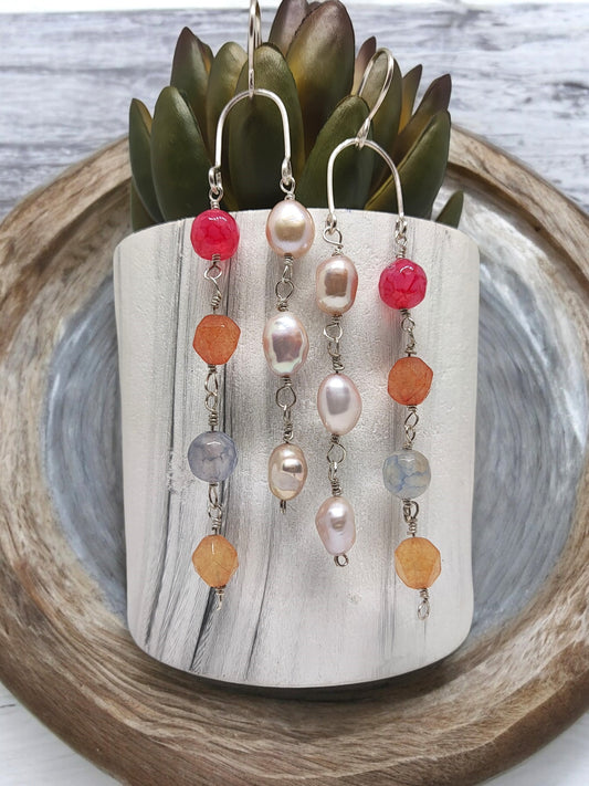 Artisan sterling silver earrings with colorful beads and pearls displayed on a white stand from Anusangi Collections