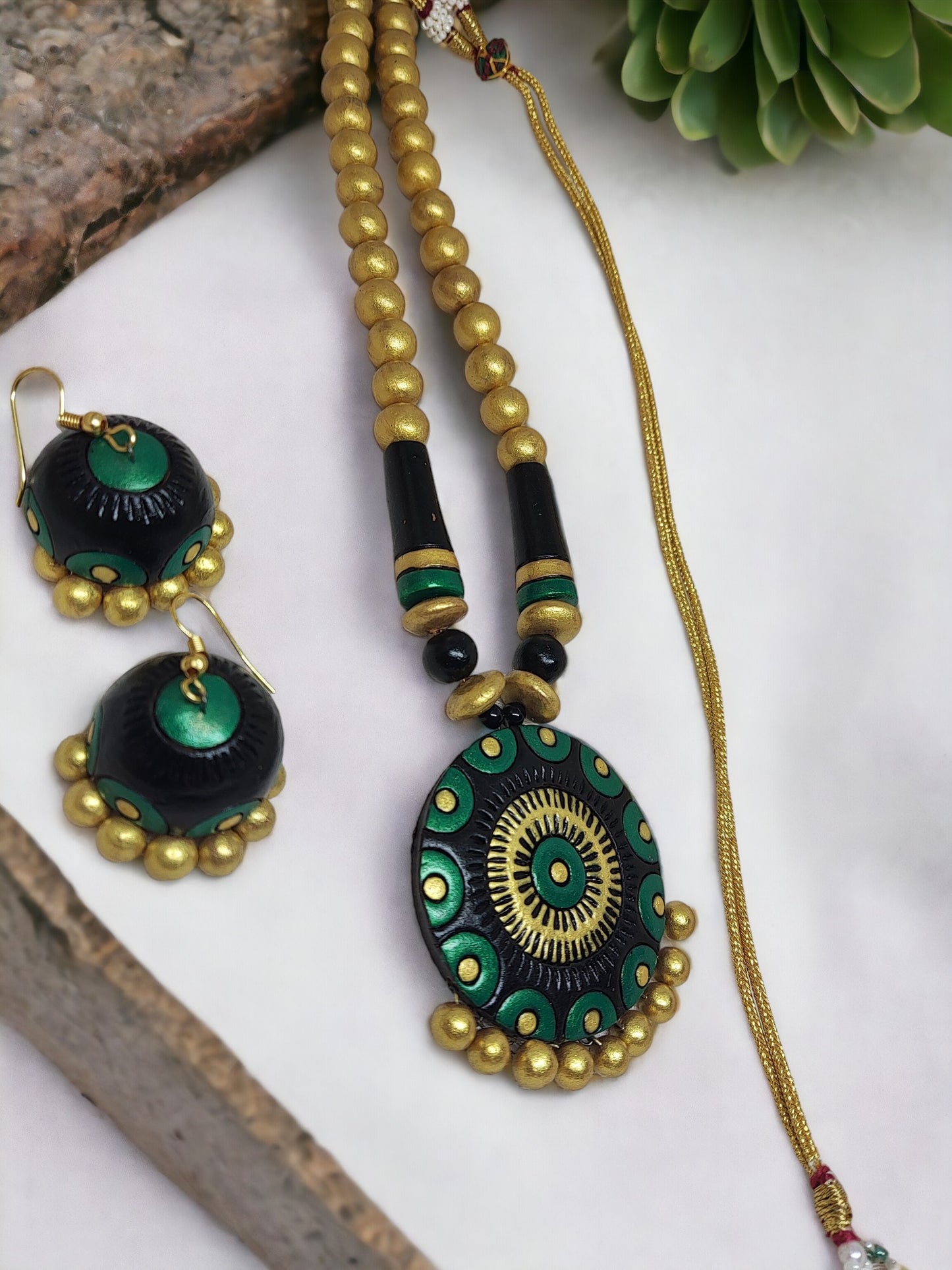 Anusangi Collections black and gold terracotta necklace with matching earrings featuring green and gold beads