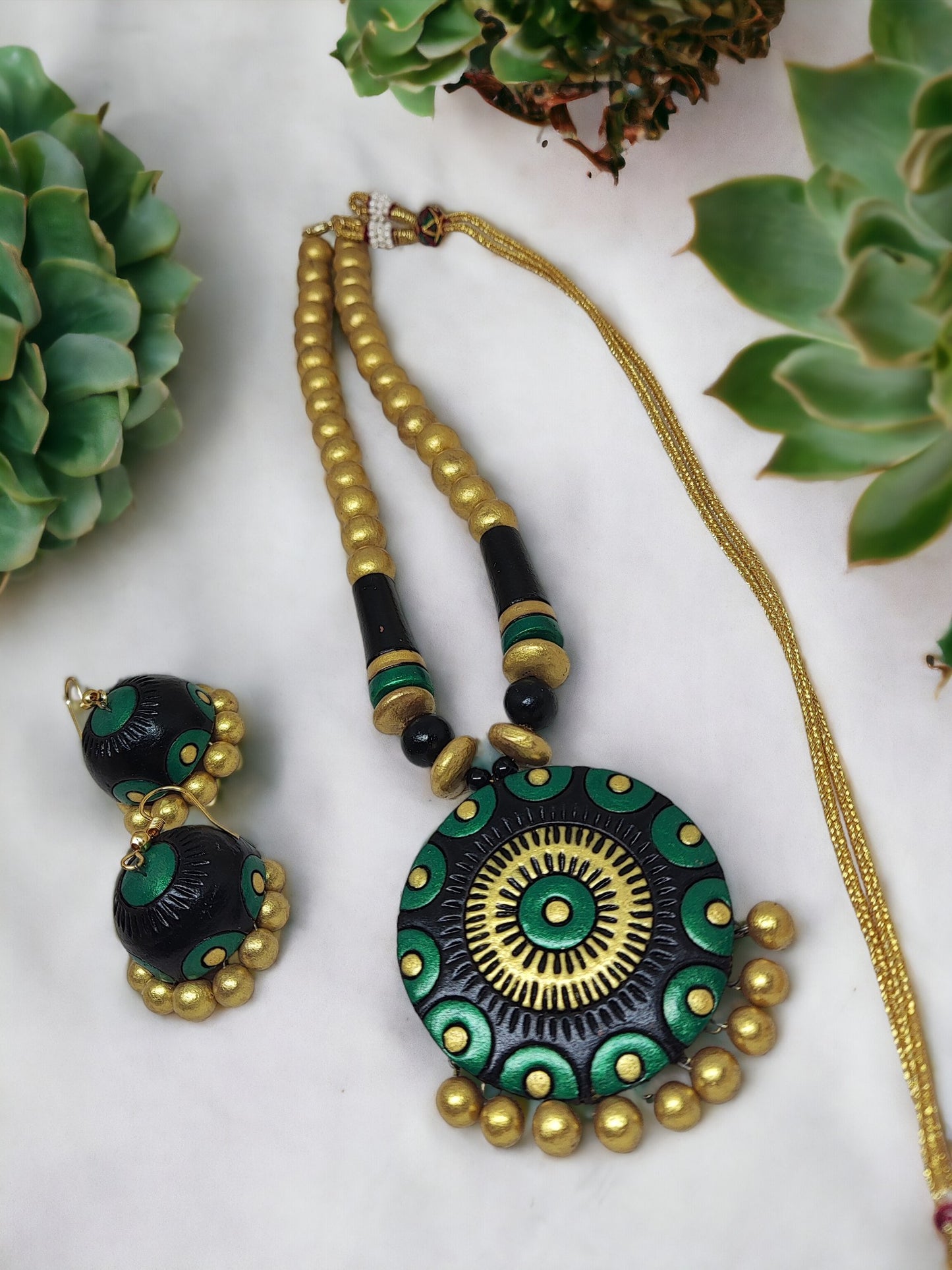 Black and gold terracotta necklace with matching earrings from Anusangi Collections displayed on white background