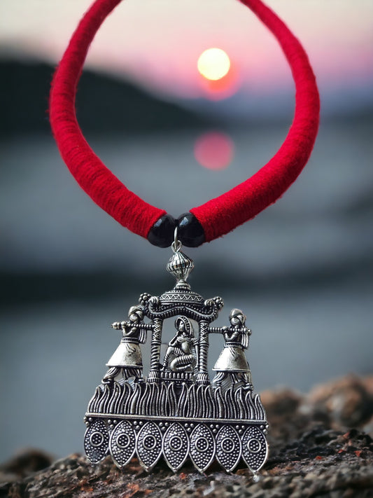 Brass necklace set with silver details featuring traditional tribal pendant on red thread