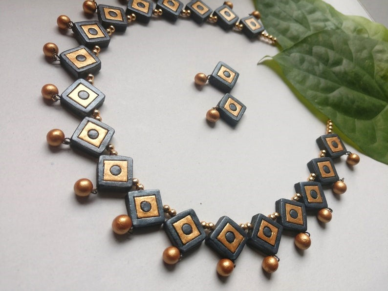 Anusangi Collections black and gold terracotta necklace set online with matching earrings and decorative beads