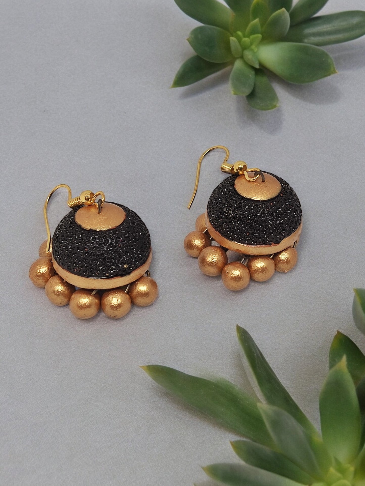 Anusangi Collections terracotta ethnic jhumka earrings for women in black and gold with round bead accents