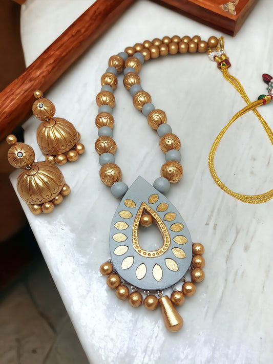 Anusangi Collections terracotta gold and gray jewelry set featuring a pendant necklace and matching earrings