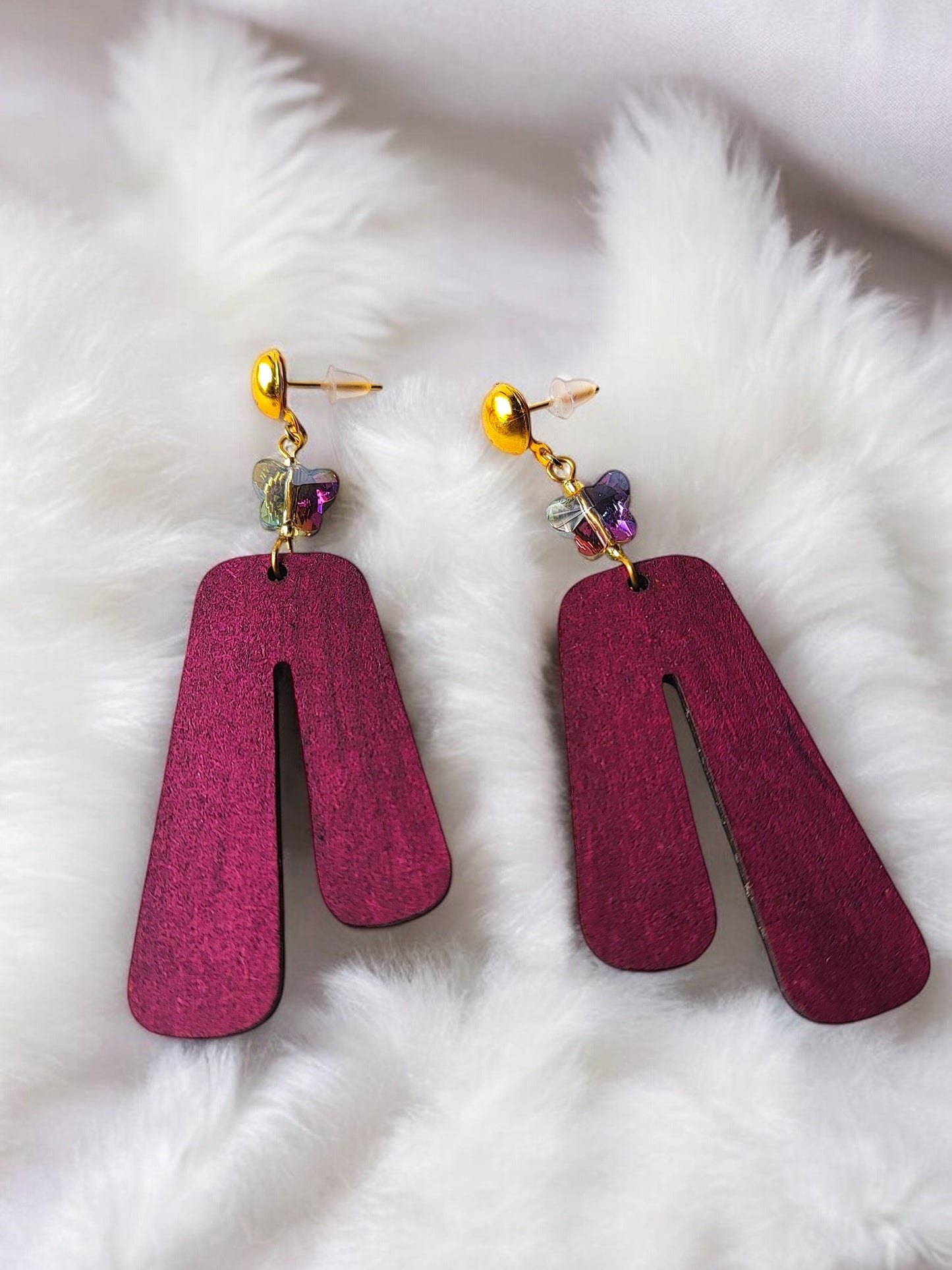 Purple wooden earrings with gold studs and decorative beads by Anusangi Collections on white fur background