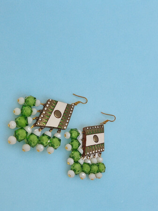 Anusangi Collections green geometric design terracotta earrings with white bead accents on blue background