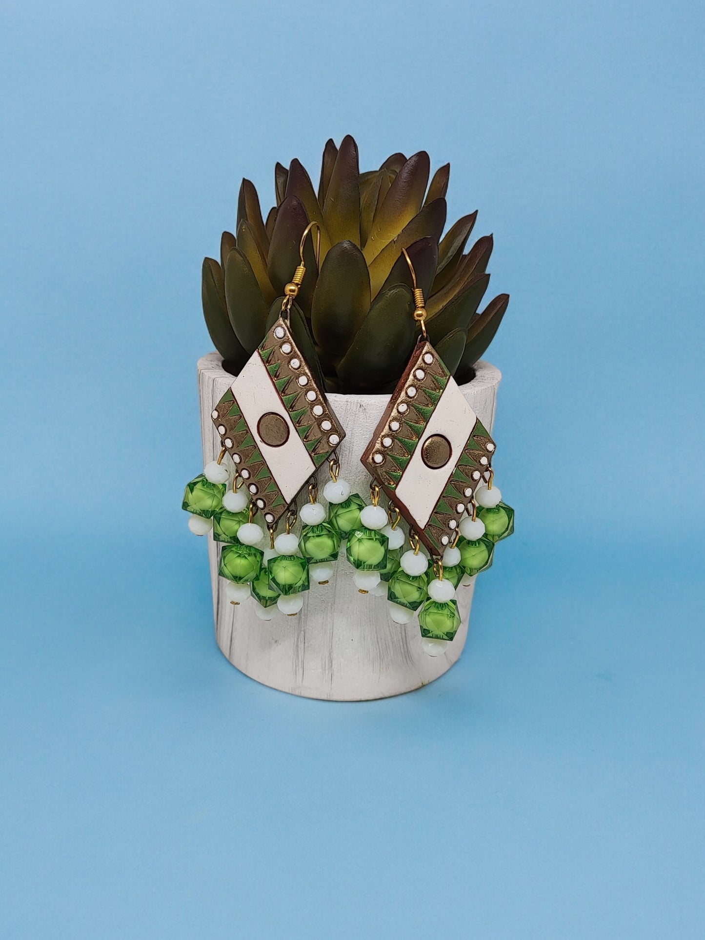 Green geometric design terracotta earrings with white accents and green bead tassels from Anusangi Collections