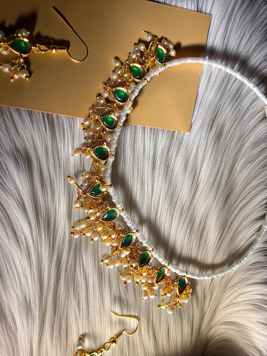 Handmade gold necklace with emerald green beads featuring intricate designs and pearl accents