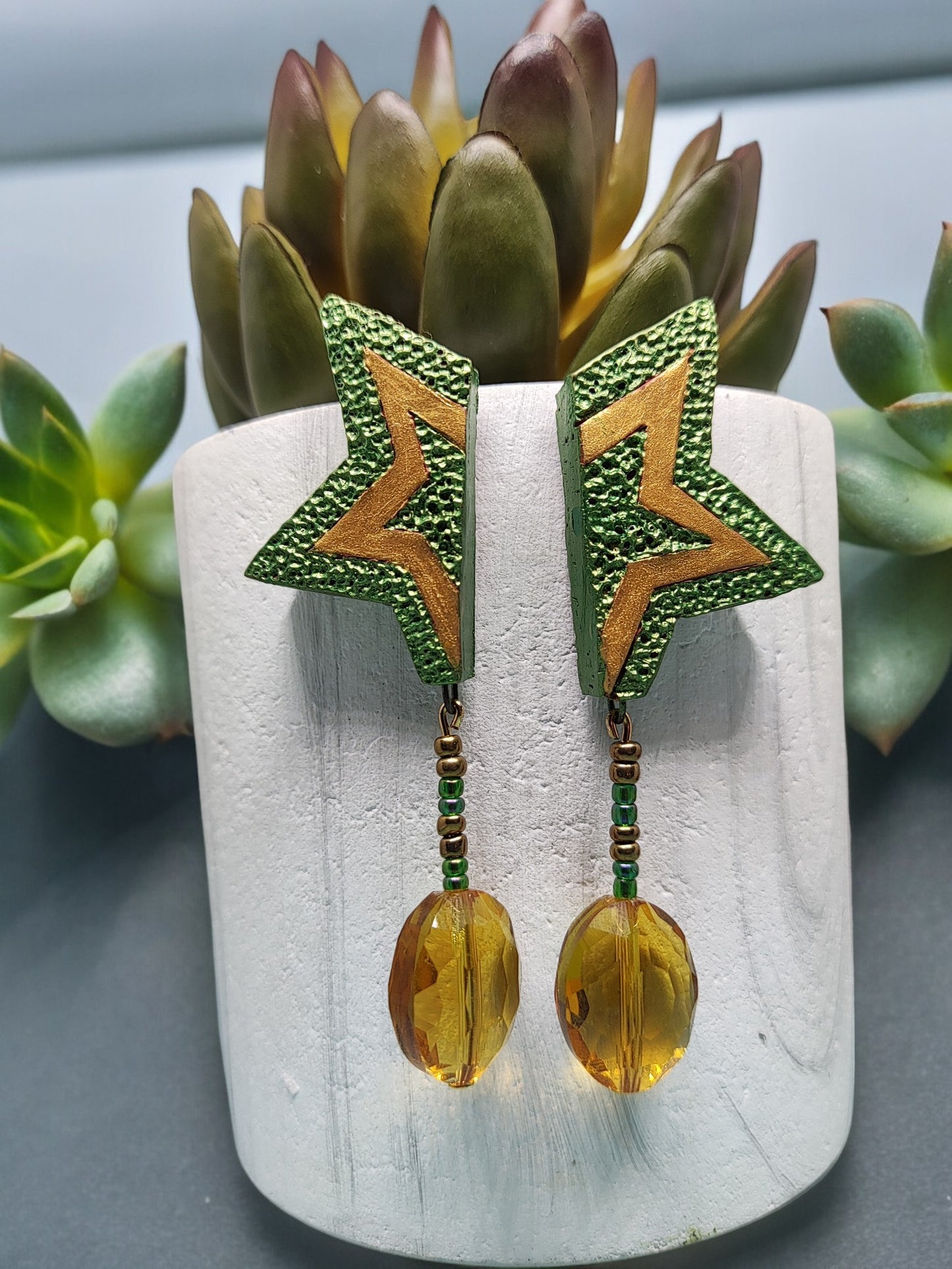 Green terracotta earrings star shaped with amber beads by Anusangi Collections displayed on white stand