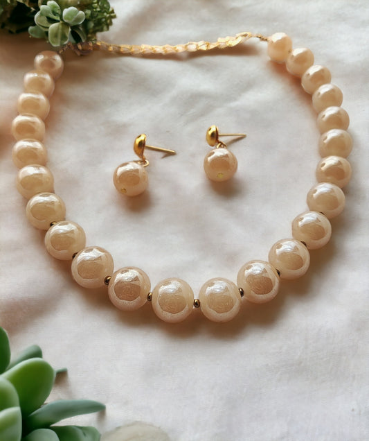 Handmade pearl necklace and earrings set by Anusangi Collections with round pearls on white background