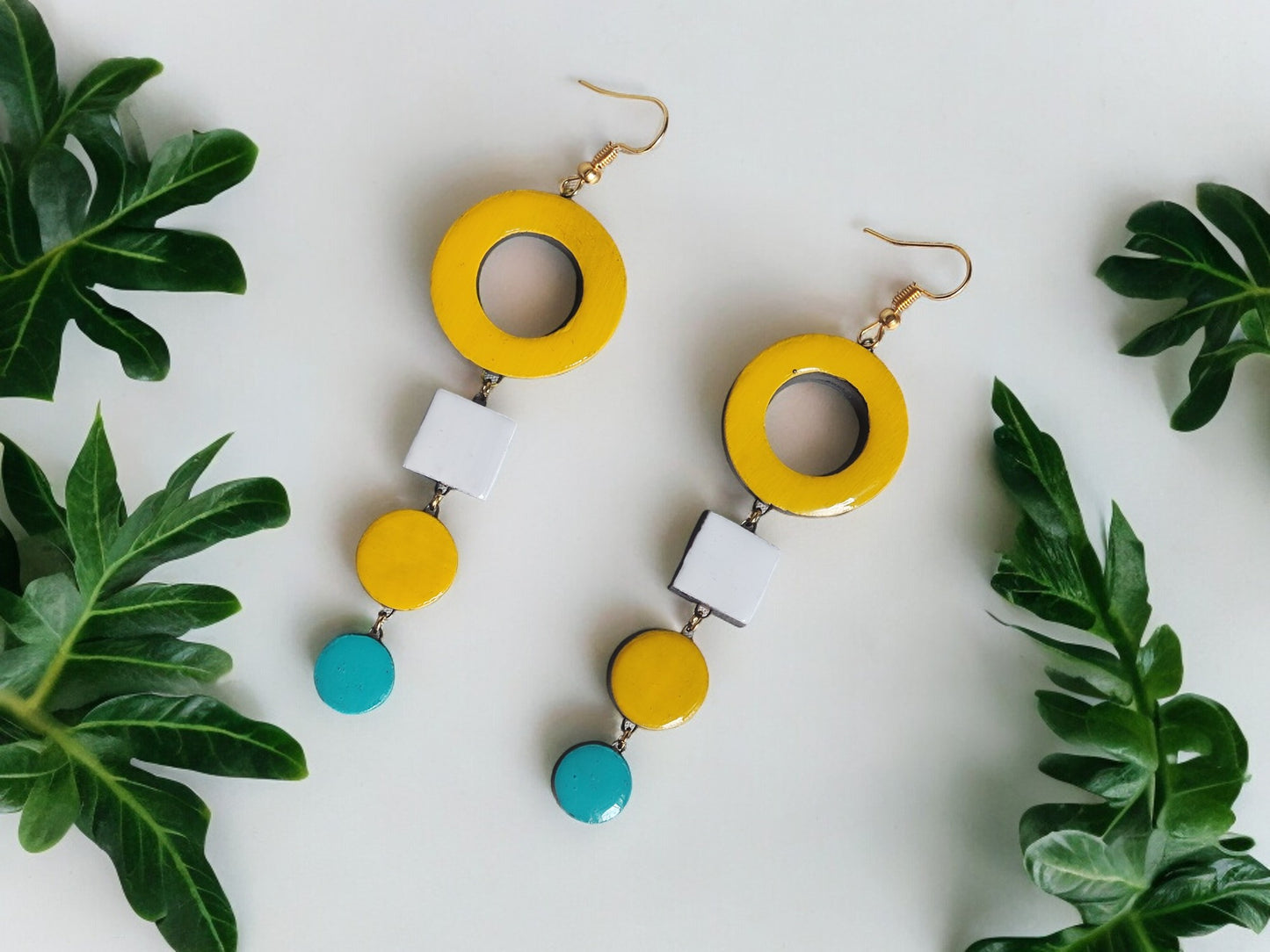 Handmade terracotta earrings in yellow, white, and turquoise with geometric shapes by Anusangi Collections