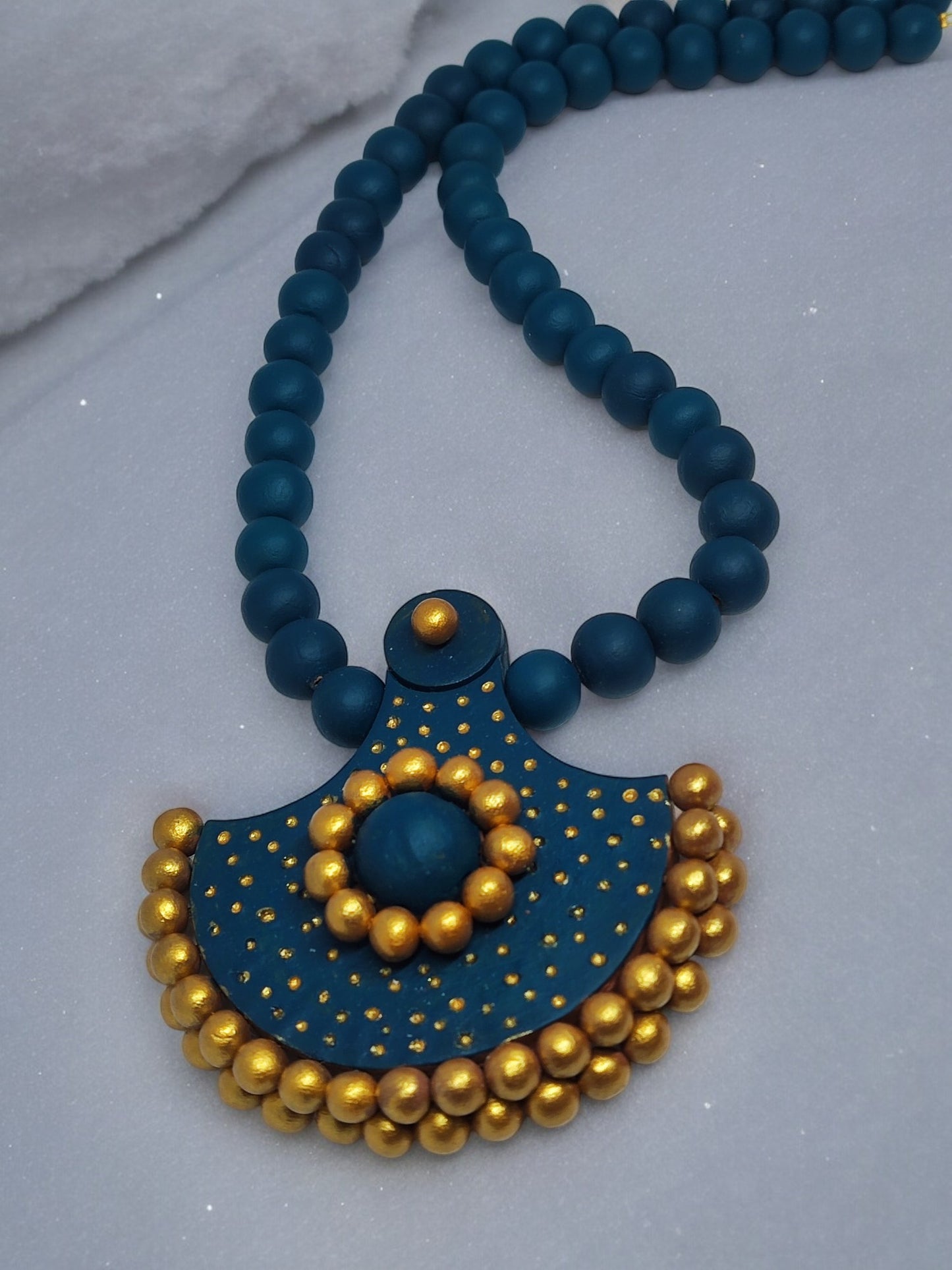 Handmade terracotta necklace and earrings featuring blue beads and gold detailing from Anusangi Collections