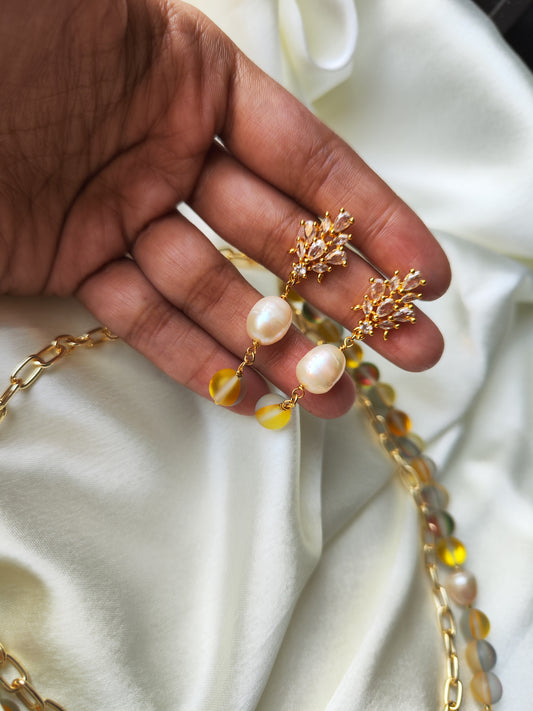 Hand holding Juliet Beaded Jewelry set featuring gold and pearl earrings from Anusangi Collections