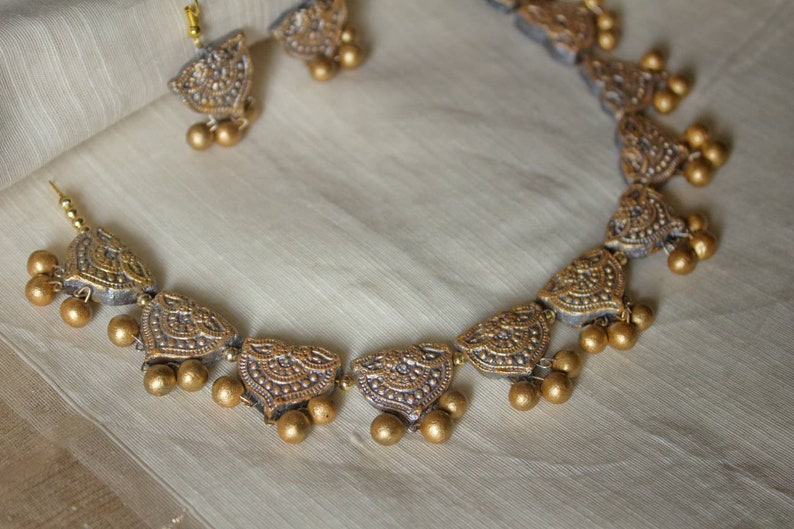 Anusangi Collections terracotta jewelry set featuring a lustrous necklace for special occasions with intricate gold-tone detailing
