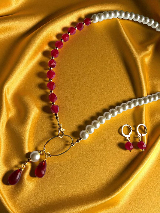 Elegant maroon and pearl jewelry set featuring a necklace and matching earrings on a golden fabric background