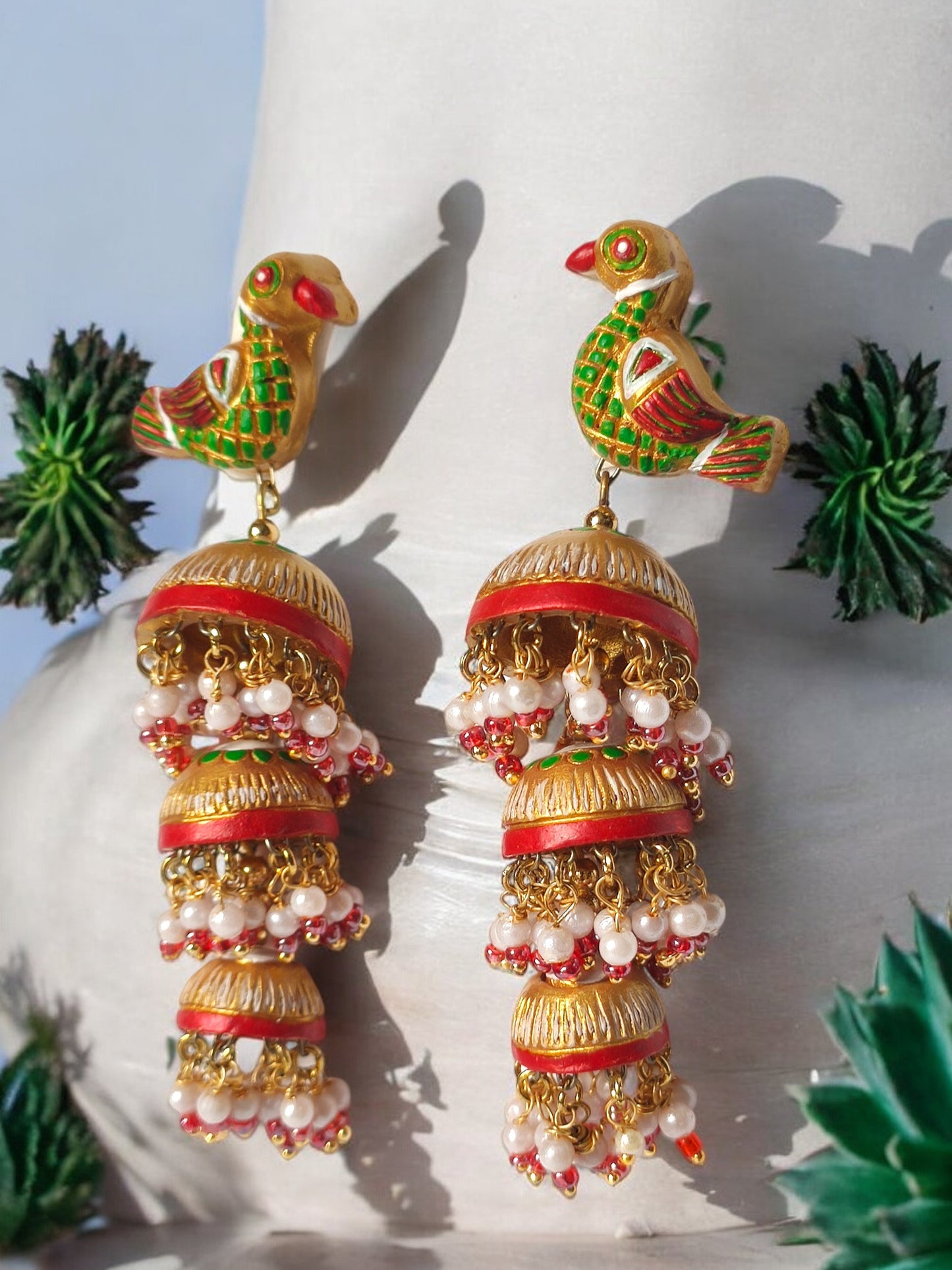 Parrot motif terracotta jhumka earrings from Anusangi Collections featuring colorful handcrafted design and pearl embellishments