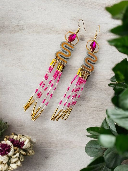 Pink and gold dangle earrings featuring intricate bead designs and elegant tassels
