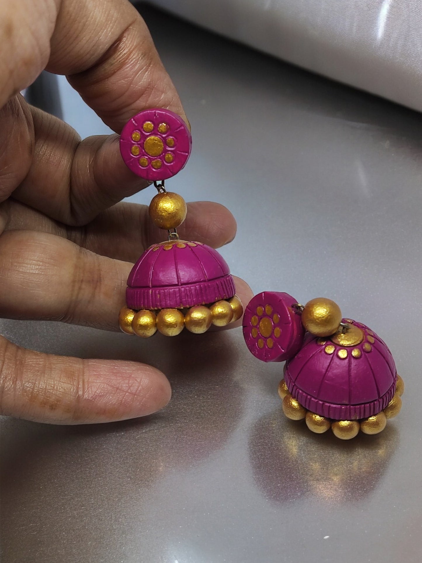 Pink terracotta jhumka earrings with golden bead accents from Anusangi Collections