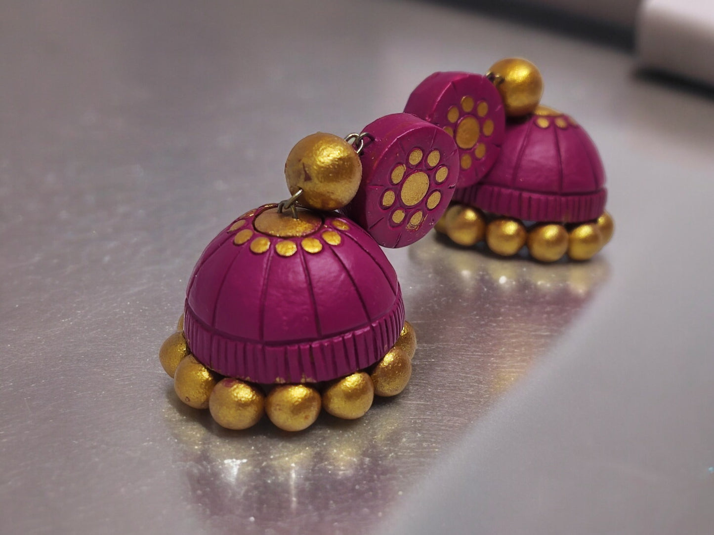 Pink terracotta jhumka earrings from Anusangi Collections with gold bead accents and floral design