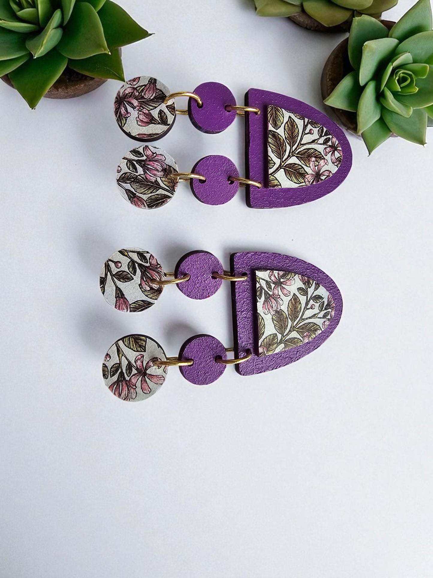 Purple earrings with floral patterns on a white background
