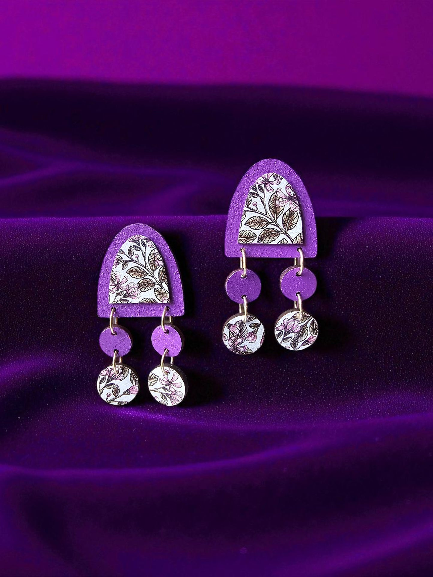 Purple and silver earrings on a purple fabric background