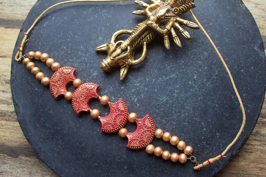Scarlet terracotta necklace set from Anusangi Collections with intricate red crescent designs and bead detailing