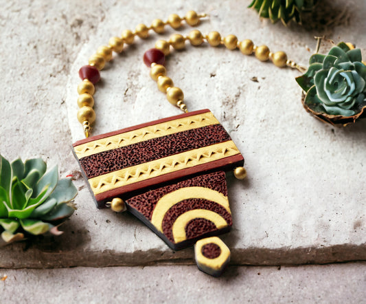 Shravya Terracotta necklace and earrings set featuring an earthy geometric pendant with gold and maroon accents