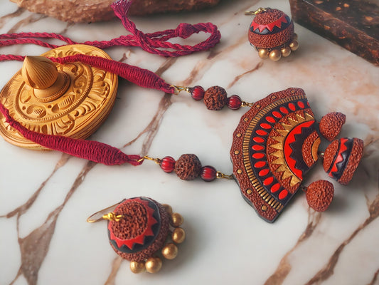 Siara terracotta jewelry set from Anusangi Collections featuring red and brown handcrafted necklace and matching earrings