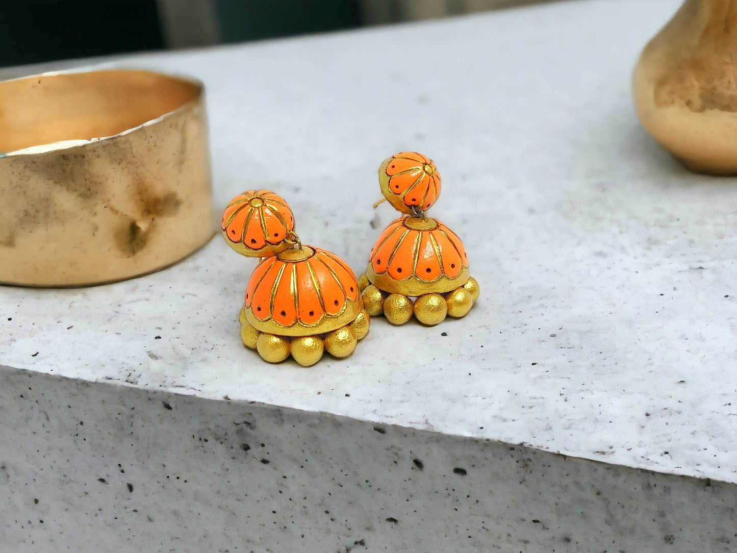 Orange and gold Anusangi Collections terracotta jhumka earrings with detailed floral design