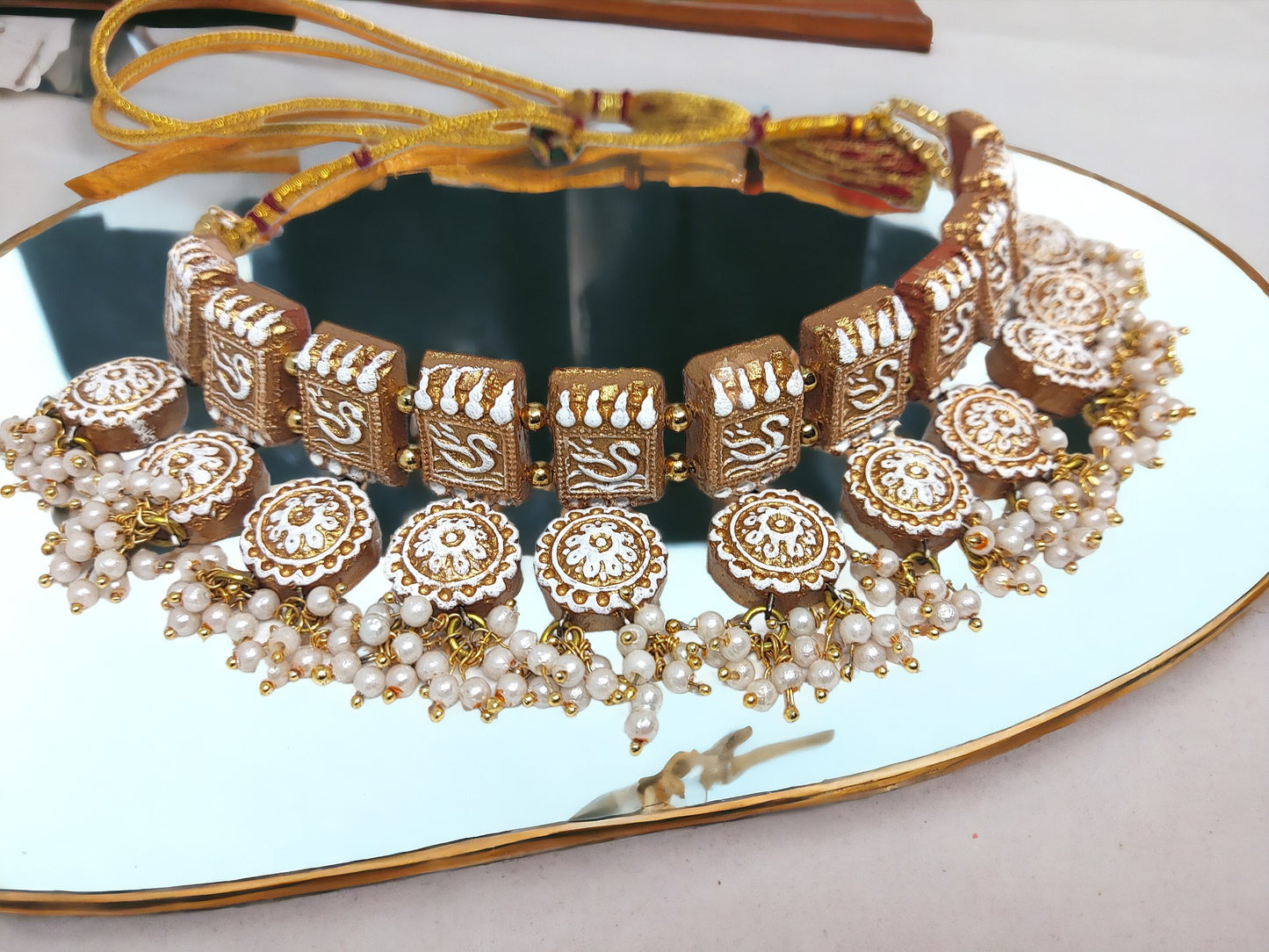 Anusangi Collections terracotta traditional fabric choker necklace with intricate white and gold design and pearl accents