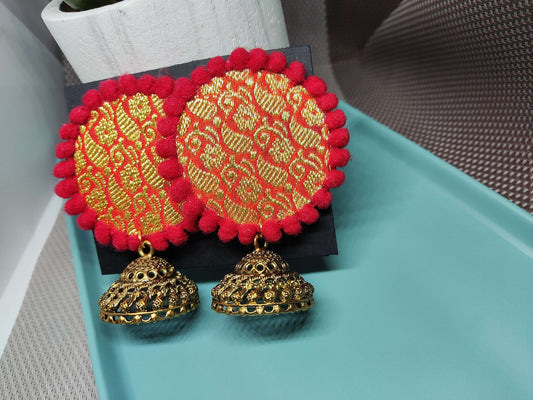 Anusangi Collections Traditional Indian Jewelry Set featuring vibrant red and gold fabric earrings with intricate designs and jhumka bells