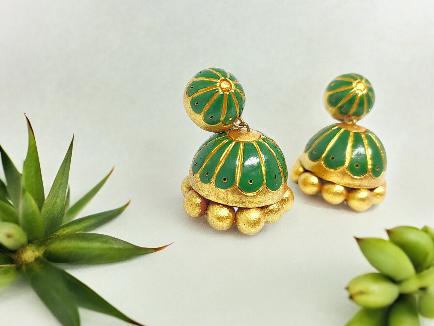 Unique green terracotta jhumkas with gold detailing and bead accents from Anusangi Collections