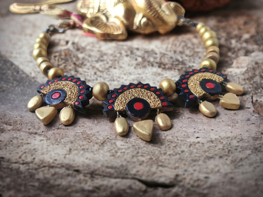 Varenya Terracotta necklace and earrings set by Anusangi Collections featuring black and gold tribal design