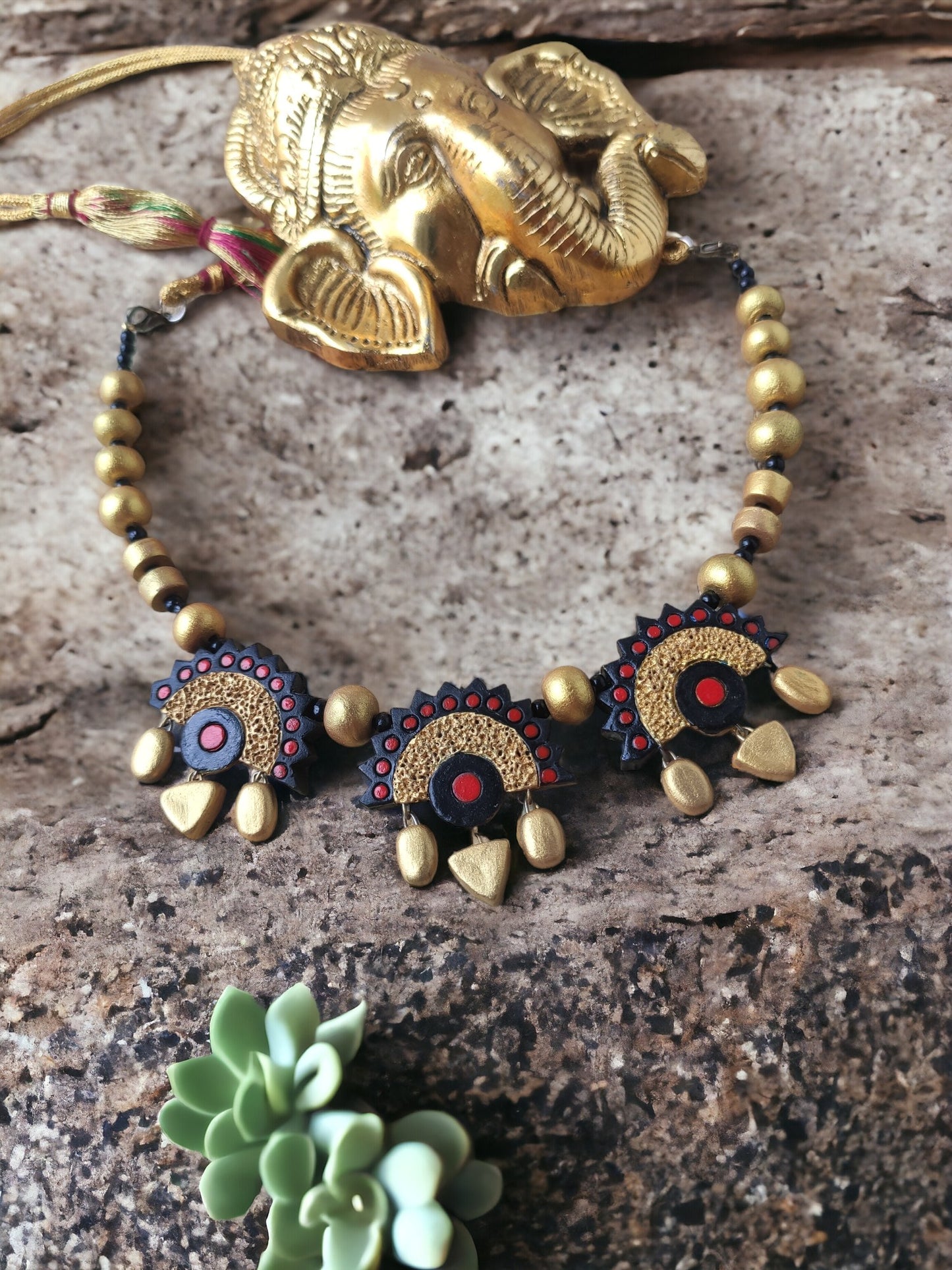 Varenya Terracotta necklace and earrings set featuring intricate black and gold design with decorative beads