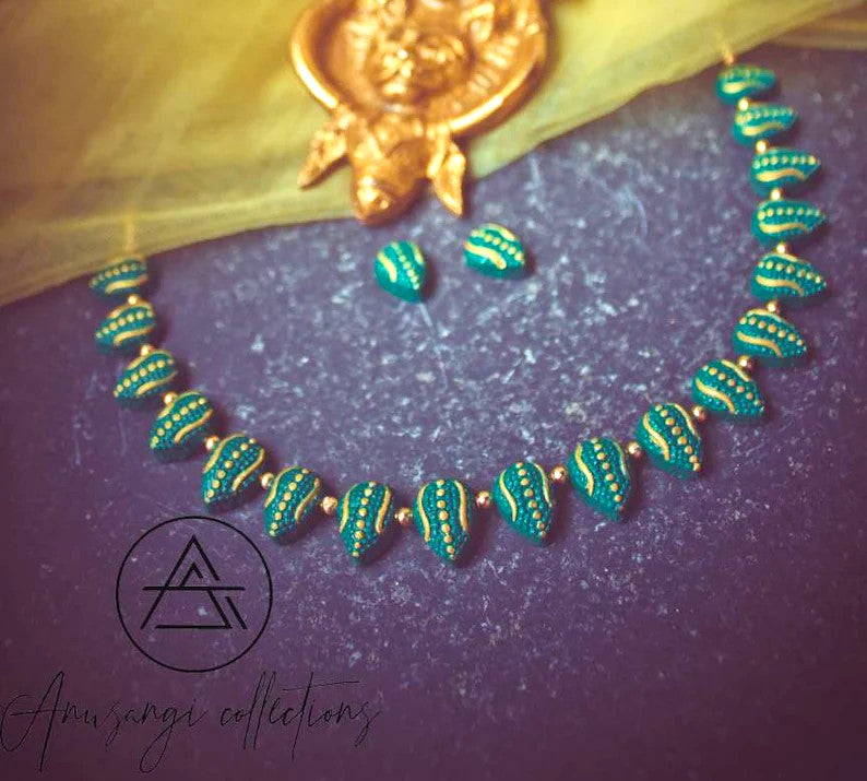 Varka terracotta jewelry set by Anusangi Collections featuring green and gold hand-painted necklace and earrings
