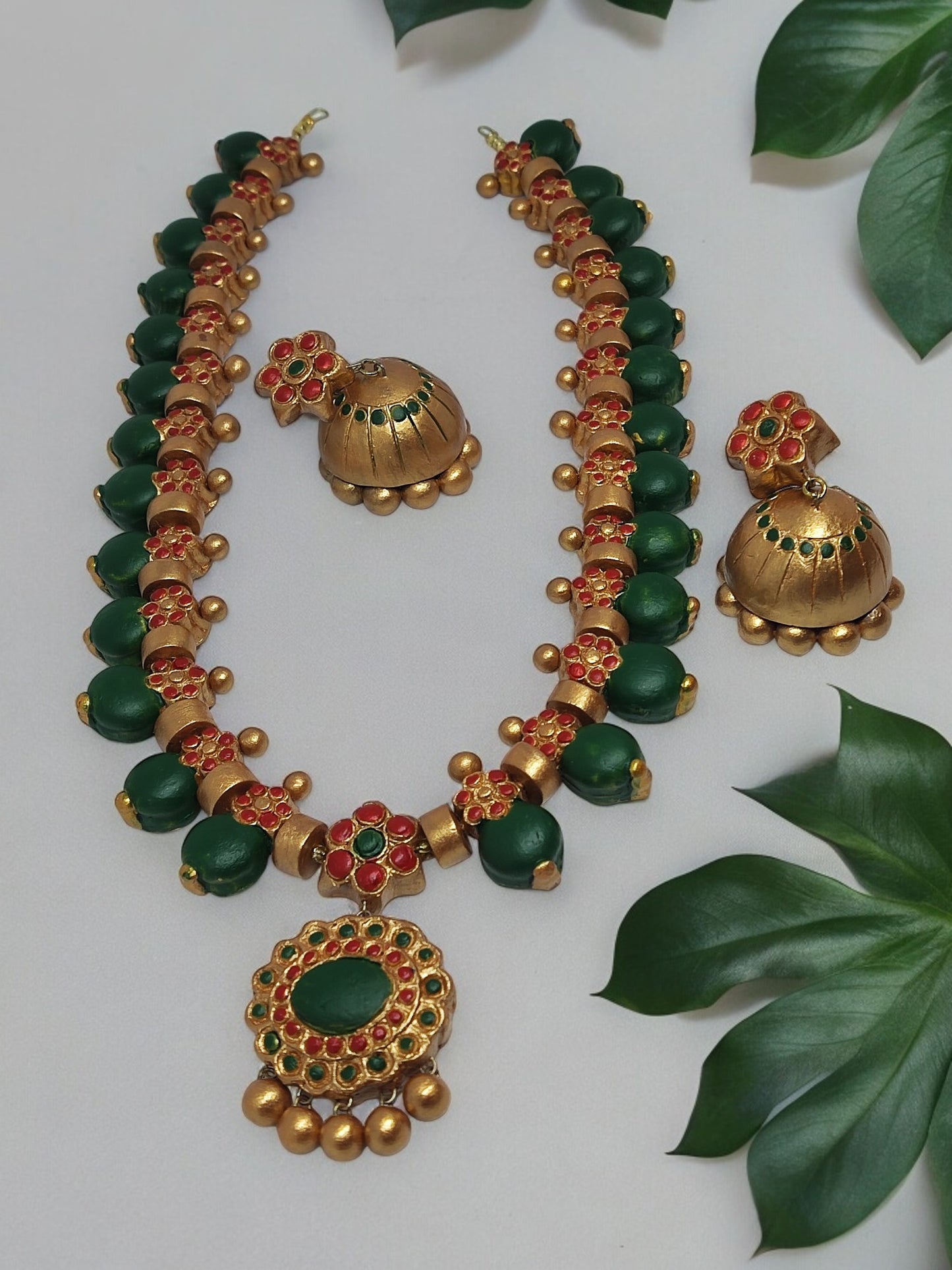 Grand terracotta necklace and earrings with green and gold intricate design from Anusangi Collections