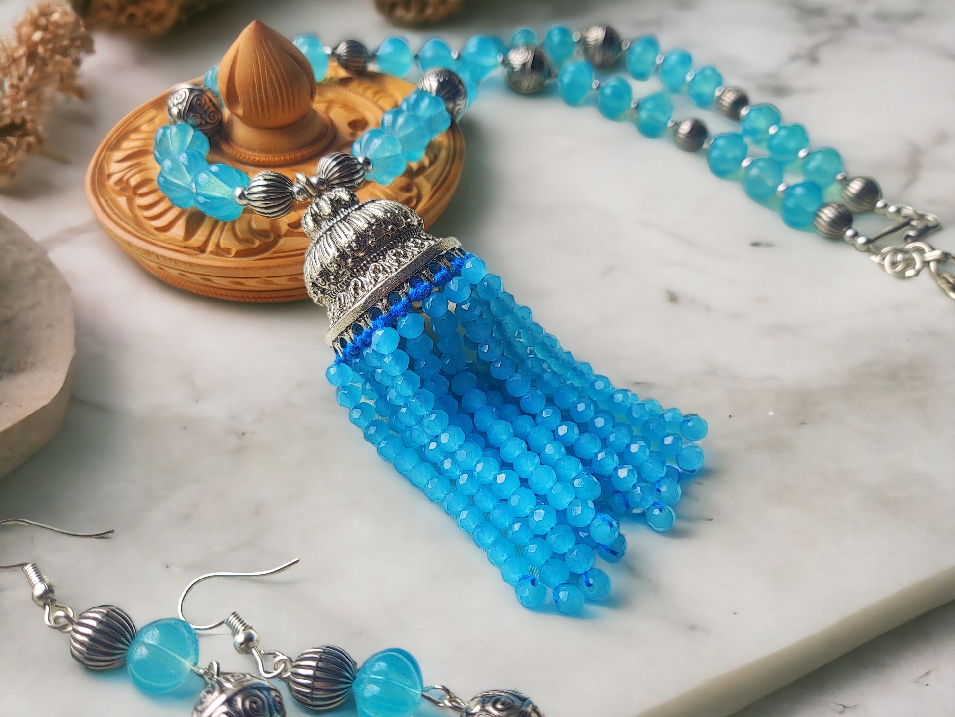 Expertly crafted with stunning blue beads, the Nilima jewelry set is the perfect accessory to elevate any outfit. Handmade with care, this set exudes elegance and sophistication. The intricate design and high quality materials make it a timeless addition to your collection.