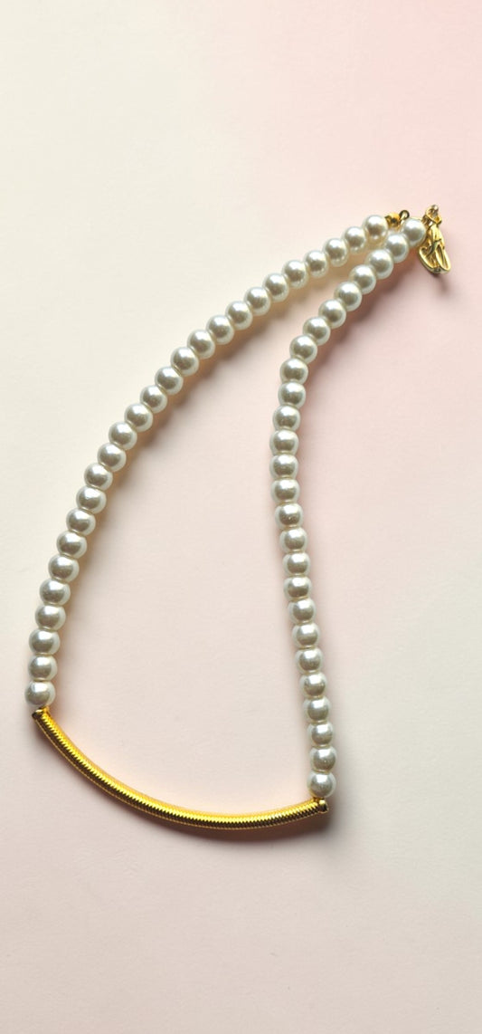 Minimal pearl necklace with gold curved bar worn by model elegant everyday jewelry