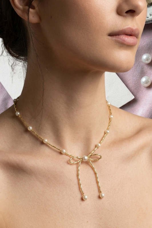 Woman wearing a delicate pearl necklace with a blurred background