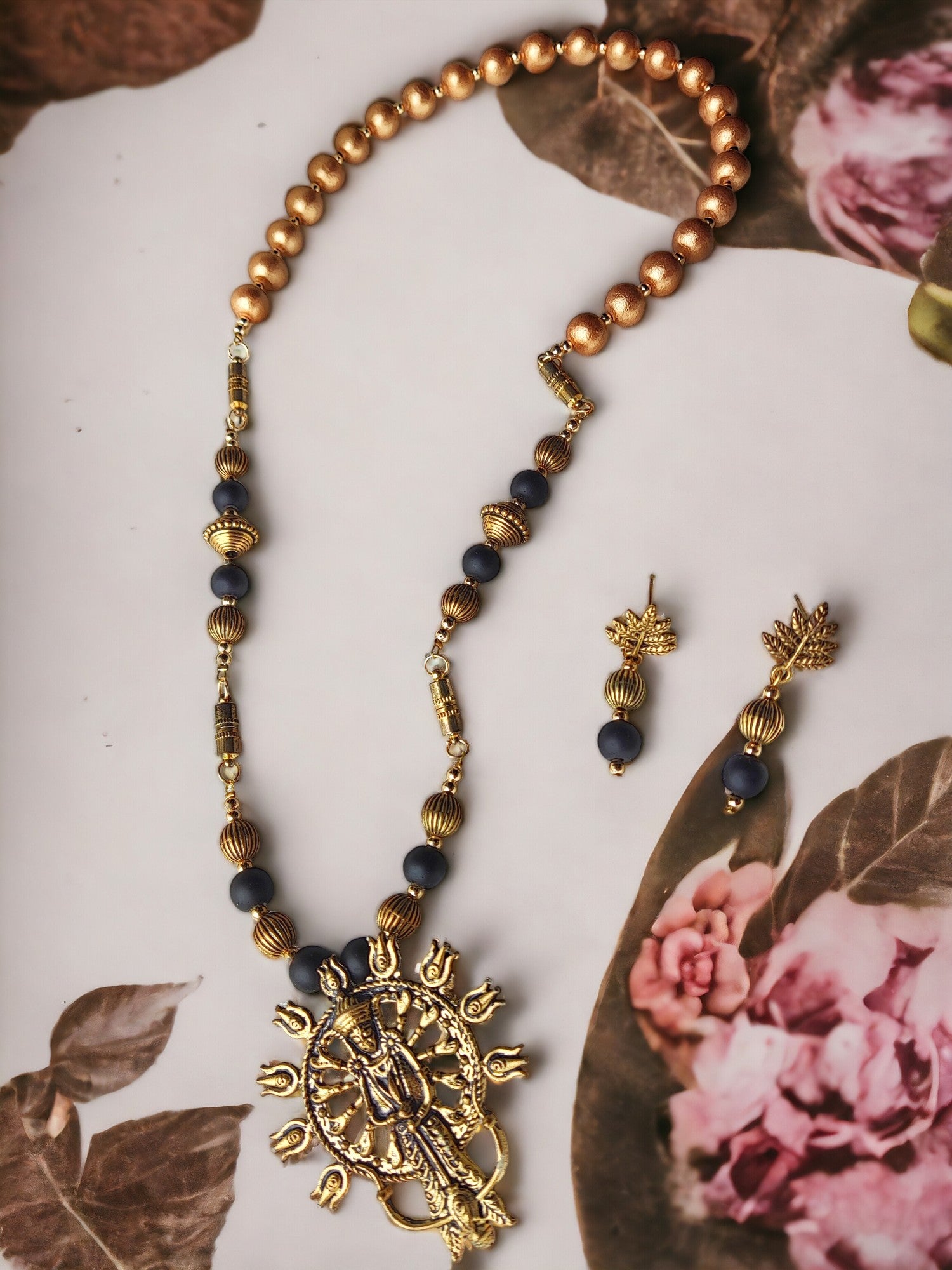 This jewelry set, titled Durga 4 in 1 style, is composed of metal components and embellished with Terracotta beads. Its versatility and ease of wear make it the perfect accessory for any occasion.