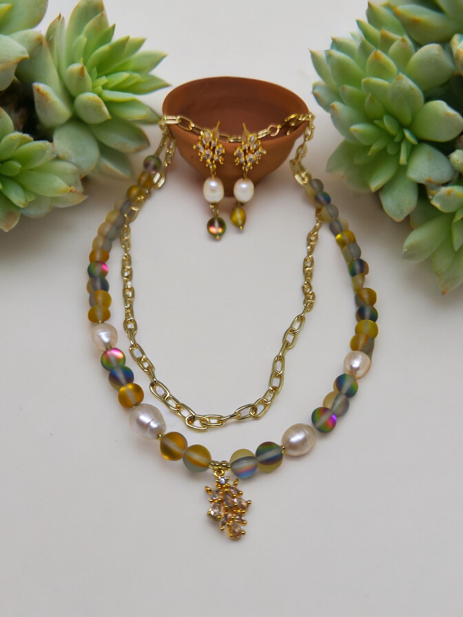 Add some shimmer to your look with the Juliet Beaded Jewelry set. Featuring mother of pearl beads, anti tarnish chains, and aura beads with CZ charms, this set is both stylish and durable. Shine bright with this unique and playful accessory. (No more jewelry-tarnishing woes for you!)