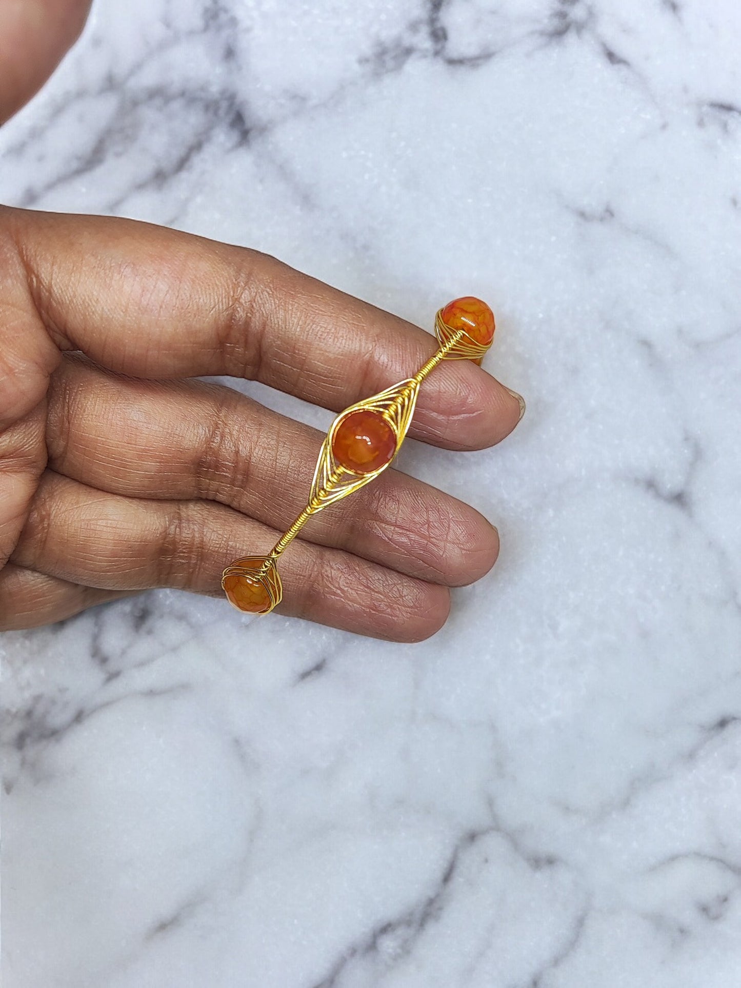 <p data-mce-fragment="1">Add a pop of color and style to any outfit with the playful Clarissa Wire Wrap Bracelet. Featuring vibrant orange Agate beads wrapped in golden wire, this bracelet is adjustable for the perfect fit. Accessorize with a touch of quirky charm!</p>