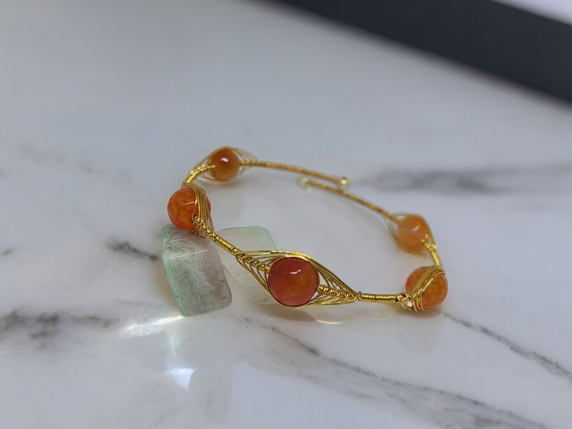 <p data-mce-fragment="1">Add a pop of color and style to any outfit with the playful Clarissa Wire Wrap Bracelet. Featuring vibrant orange Agate beads wrapped in golden wire, this bracelet is adjustable for the perfect fit. Accessorize with a touch of quirky charm!</p>