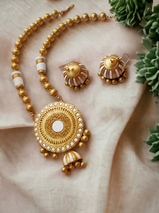 Aadhira terracotta jewelry set by Anusangi Collections featuring gold and white detailed necklace with matching earrings